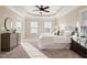 Bright main bedroom featuring plush carpet, tray ceiling, and sunlit windows with street views at 9 Water Stone Ct, Durham, NC 27705