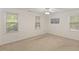 Carpeted bedroom featuring neutral walls, a ceiling fan, and two large windows at 901 Emory Ln, Raleigh, NC 27609