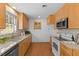 Bright kitchen featuring modern stainless steel appliances, wooden cabinetry, and natural light at 901 Emory Ln, Raleigh, NC 27609