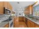 Open kitchen area featuring stainless steel appliances, wooden cabinetry, and tile backsplash at 901 Emory Ln, Raleigh, NC 27609