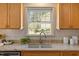 Granite kitchen countertop featuring a double sink, wood cabinets, stainless steel dishwasher and tile backsplash at 901 Emory Ln, Raleigh, NC 27609