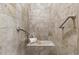 Stylish shower with a built-in bench, grab bars, and neutral toned tiles at 901 Emory Ln, Raleigh, NC 27609