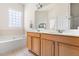 Bright bathroom featuring double vanities, soaking tub, and a large mirror at 922 Tupelo Glen Ct, Fuquay Varina, NC 27526