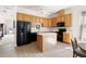 Functional kitchen with wood cabinets, black appliances, and a convenient center island at 922 Tupelo Glen Ct, Fuquay Varina, NC 27526
