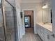Well-lit bathroom with white cabinets, gray tiled floors and glass enclosed shower at 101 Maroon Ct, Raleigh, NC 27610