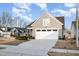 Home featuring a two-car garage, gray siding, and trimmed landscaping, with a neighborhood in the background at 101 Maroon Ct, Raleigh, NC 27610