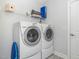 Functional laundry room with modern washer and dryer and storage shelves at 101 Maroon Ct, Raleigh, NC 27610