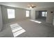 Large, sunlit bedroom with plush carpet, two windows, and a ceiling fan at 110 Manor Stone Dr, Clayton, NC 27527