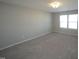 Neutral carpet and a window for natural light accentuates this spacious bedroom at 110 Manor Stone Dr, Clayton, NC 27527