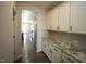 Walk-in pantry with granite countertops and white cabinets for ample storage at 110 Manor Stone Dr, Clayton, NC 27527
