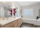 Bright bathroom with a double vanity, glass block window, and soaking tub at 113 Valley Ln, Pittsboro, NC 27312