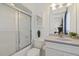 Well-lit bathroom boasts a shower-tub combination with glass doors and white vanity at 113 Valley Ln, Pittsboro, NC 27312