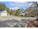 Light gray home with a large driveway and two-car garage, surrounded by mature trees at 113 Valley Ln, Pittsboro, NC 27312