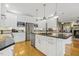 Modern kitchen with white cabinets, stainless steel appliances, granite countertops, and hardwood flooring at 113 Valley Ln, Pittsboro, NC 27312