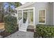 Sunroom entrance with white stairs and decorative trim, surrounded by lush greenery at 113 Valley Ln, Pittsboro, NC 27312