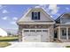 Two car garage with stone and shingle accents, and overhead lighting at 115 S Harper Faith Way, Benson, NC 27504