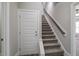 Carpeted stairs feature a wooden handrail leading to upper levels of the home at 115 S Harper Faith Way, Benson, NC 27504
