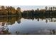 Calm lake reflecting trees and sky, enhancing the property's serene and natural beauty at 116 Lakeshore Dr, Durham, NC 27713