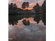 Picturesque sunset reflecting off a tranquil pond with trees silhouetted against the colorful sky at 116 Lakeshore Dr, Durham, NC 27713
