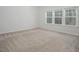 Bright bedroom featuring neutral carpet, large windows offering an inviting and comfortable atmosphere at 117 Gravel Brook Ct, Cary, NC 27519