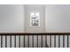Upstairs hallway featuring a decorative window, railing, and downstairs door at 117 Gravel Brook Ct, Cary, NC 27519