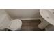 Close-up of toilet and sink in bathroom with wood-look flooring at 11700 Coppergate Dr # 105, Raleigh, NC 27614