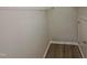 Walk-in closet with wire shelving and wood-look flooring, next to a door at 11700 Coppergate Dr # 105, Raleigh, NC 27614