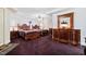 Spacious bedroom featuring two beds, elegant wooden furniture, and warm, purple carpeting at 119 Cardinal Crest Ct, Pittsboro, NC 27312