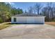 Detached garage with three bays and large driveway, as well as some surrounding vegetation at 119 Cardinal Crest Ct, Pittsboro, NC 27312