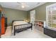 Comfortable bedroom with great natural light, ceiling fan, view to mature trees, and a full bookcase at 12 Montcrest Dr, Durham, NC 27713