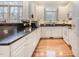Bright kitchen featuring white cabinets, modern appliances, hardwood floors, and large windows at 12 Montcrest Dr, Durham, NC 27713