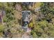 An aerial view showcases the home's roof, surrounding trees, driveway and landscaping at 122 W Woodridge Dr, Durham, NC 27707