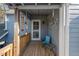 Charming back porch with wood railings, wind chimes, a chair, and a side table at 122 W Woodridge Dr, Durham, NC 27707