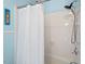 Modern bathroom features a tiled shower with a sleek showerhead and white shower curtain at 122 W Woodridge Dr, Durham, NC 27707