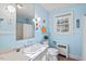Pastel blue bathroom with ceramic sink, window, and tiled floors at 122 W Woodridge Dr, Durham, NC 27707