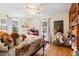 Cozy bedroom with hardwood floors, bright windows, ceiling fan, and whimsical decor at 122 W Woodridge Dr, Durham, NC 27707
