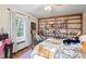 Charming bedroom with hardwood floors, filled with natural light from the window, and a custom bookshelf at 122 W Woodridge Dr, Durham, NC 27707