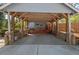 A covered carport features brick pillars, exposed beams, and a concrete driveway at 122 W Woodridge Dr, Durham, NC 27707