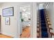 Hallway view of the Kitchen featuring hardwood floors and white cabinetry at 122 W Woodridge Dr, Durham, NC 27707