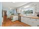 Well-lit kitchen with dining area, butcher block counters, white cabinets, and hardwood floors at 122 W Woodridge Dr, Durham, NC 27707