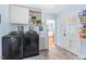 Convenient laundry room with modern washer and dryer, storage cabinets, and a utility sink at 122 W Woodridge Dr, Durham, NC 27707