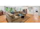 Spacious living room with hardwood floors, large sectional sofa, bright windows and open to kitchen at 122 W Woodridge Dr, Durham, NC 27707