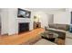 Cozy living room with hardwood floors, fireplace, and comfortable seating arrangement at 122 W Woodridge Dr, Durham, NC 27707