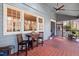 Cozy screened-in porch with red tile flooring, ceiling fan and outdoor seating area for relaxation at 122 W Woodridge Dr, Durham, NC 27707