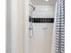 Up close view of the tiled shower with a shower curtain, and shower head at 122 W Woodridge Dr, Durham, NC 27707