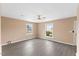 Spacious bedroom featuring new gray-tone laminate floors, a ceiling fan and large windows at 1230 Melrose Dr, Burlington, NC 27217