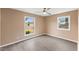 Bright bedroom with hardwood floors, fan and two windows showing a peaceful neighborhood at 1230 Melrose Dr, Burlington, NC 27217