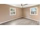 Bright bedroom with hardwood floors, fan and two windows showing a peaceful neighborhood at 1230 Melrose Dr, Burlington, NC 27217
