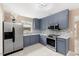 Galley kitchen featuring stainless steel appliances, gray shaker cabinets, modern backsplash, and ceramic tile flooring at 1230 Melrose Dr, Burlington, NC 27217