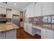 Beautiful kitchen with custom white cabinetry, granite counters, stainless steel appliances and brown tile backsplash at 125 Station Dr, Morrisville, NC 27560
